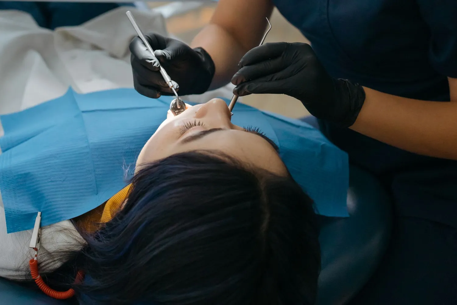 Dentist using dental instruments to examine a patient's teeth up close