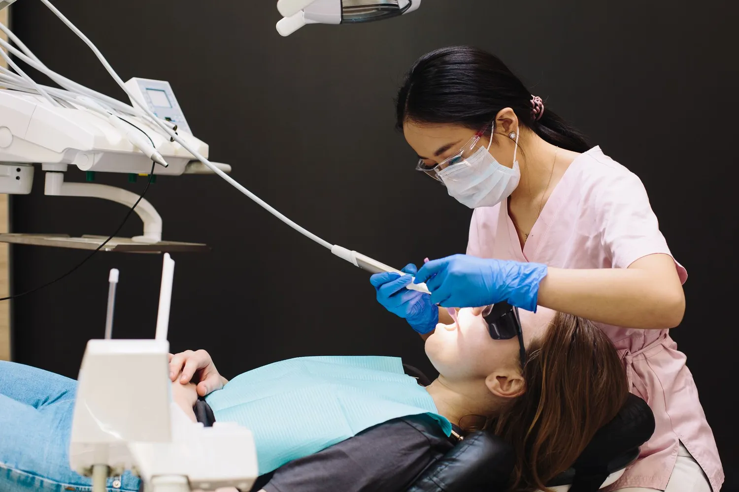 Dental professional using a scaler and mirror during a patient's clean
