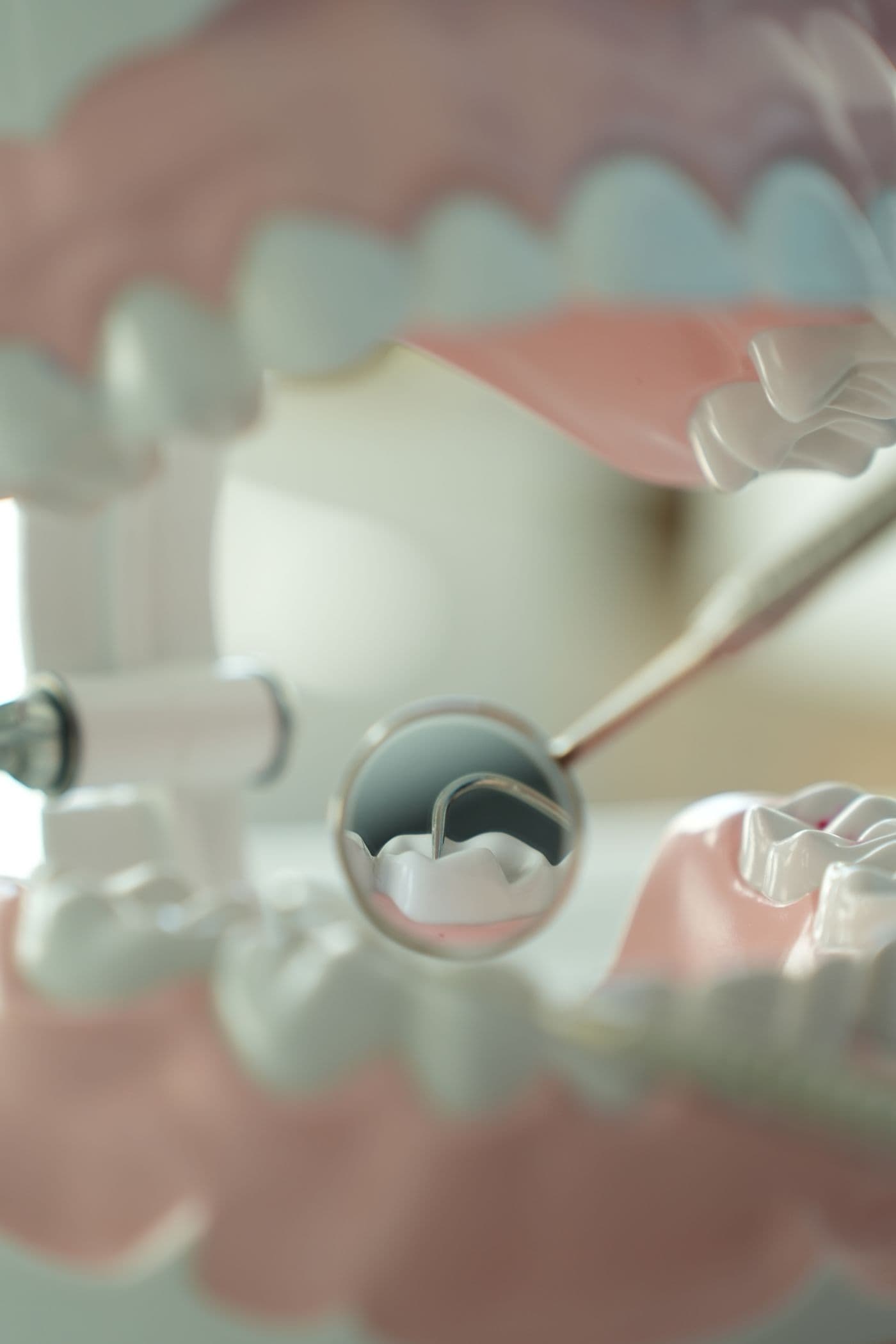 Dental mirror and probe inspecting a model set of teeth