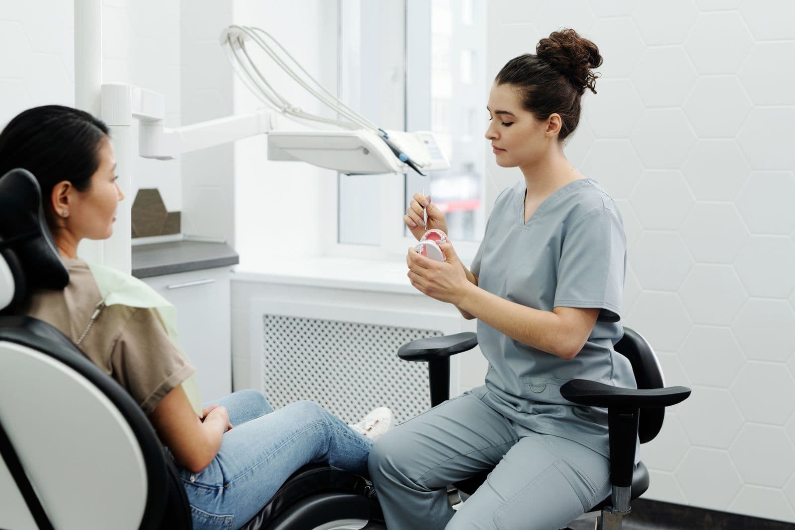 Dentist explaining treatment options to a patient using a dental model in the clinic