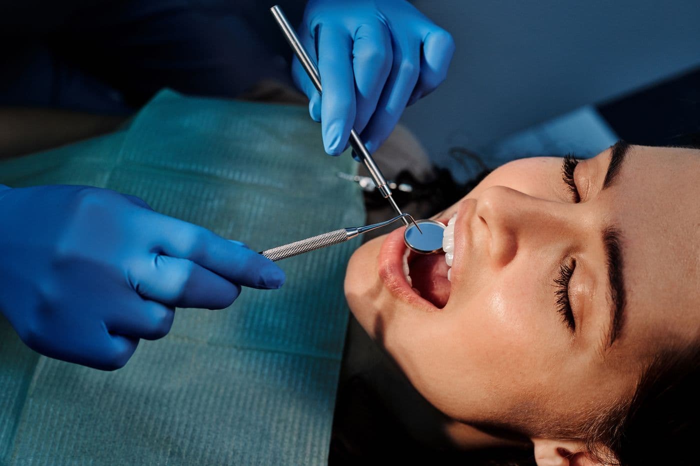 Dentist using a mirror and probe to examine a patient's front teeth