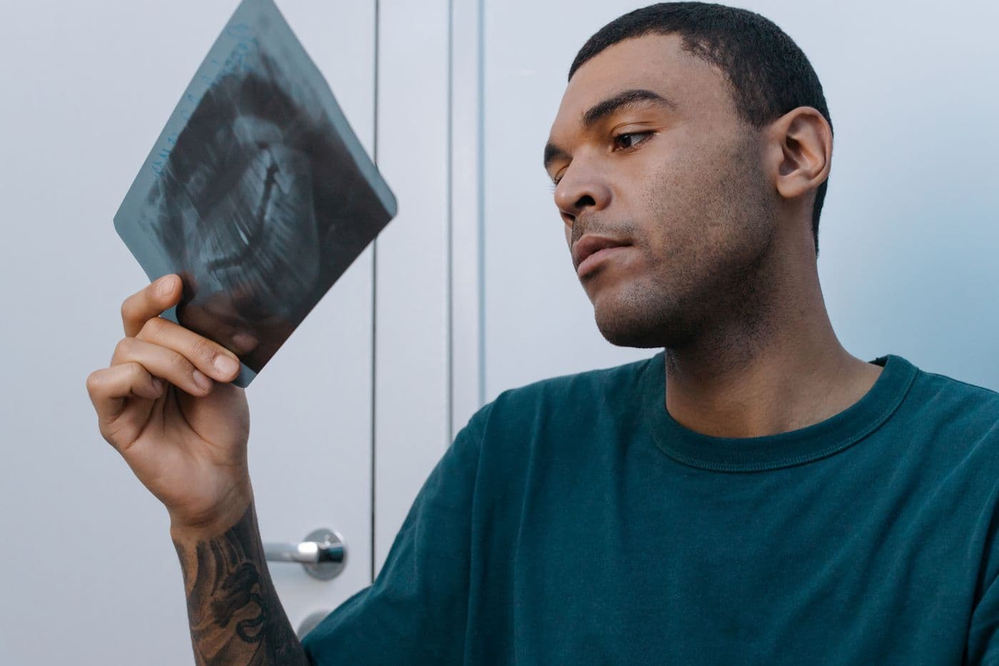 Man studying a dental X-ray film held up to the light